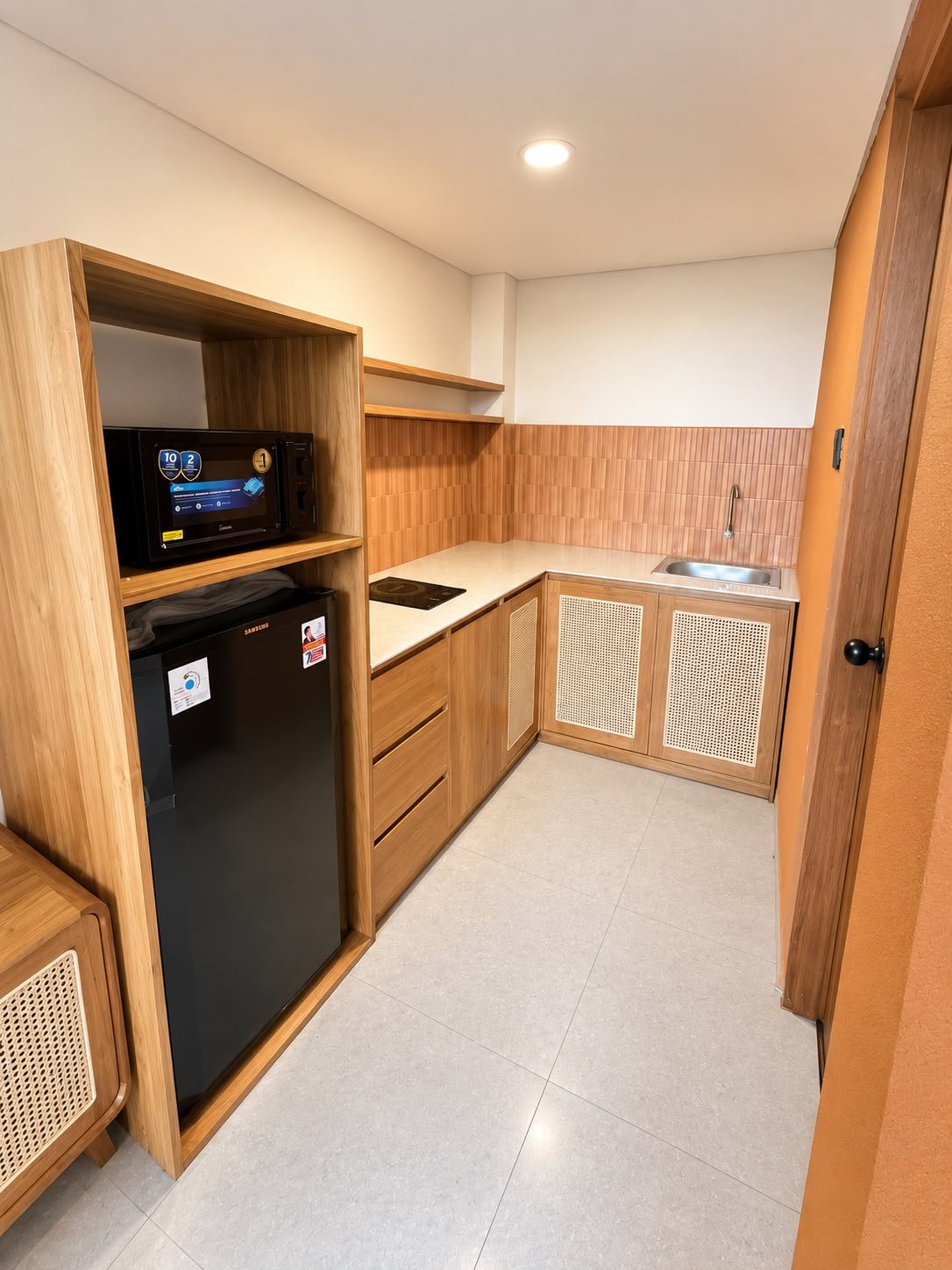 Pantry dengan kabinet kayu, rotan, dan backsplash terracotta